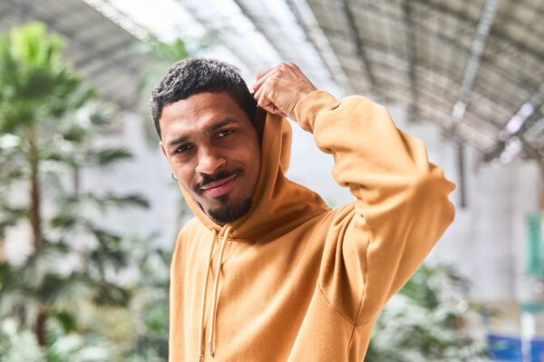 Lifestyle photo of a person wearing a modern hoodie outdoors—great for showcasing custom embroidered hoodies.
