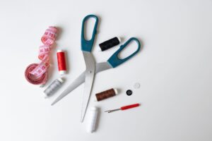 Clean product-style photo of sewing tools on white background (works as a minimal stand-in image for an embroidered patch set).